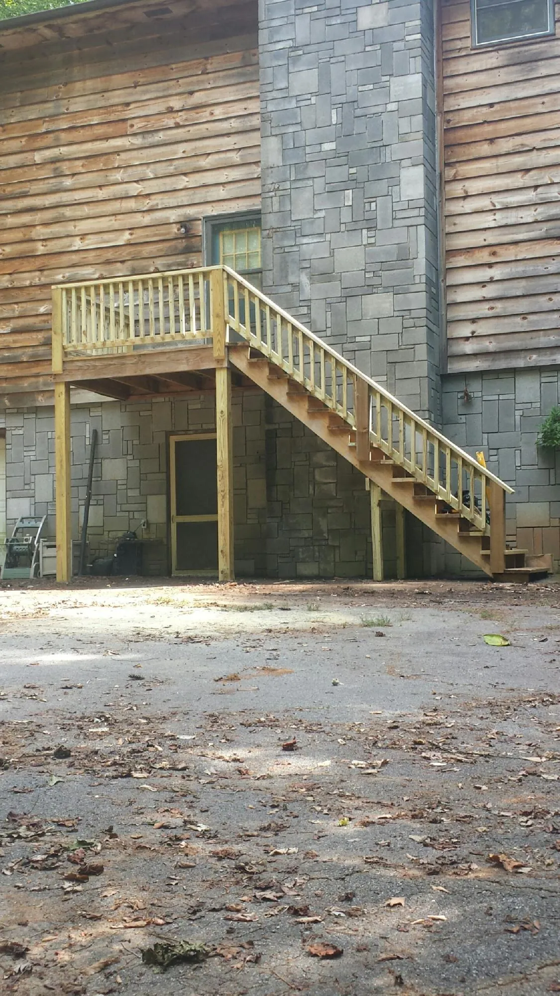 New pressure treated deck and stair landing on a log home in Okeechobee