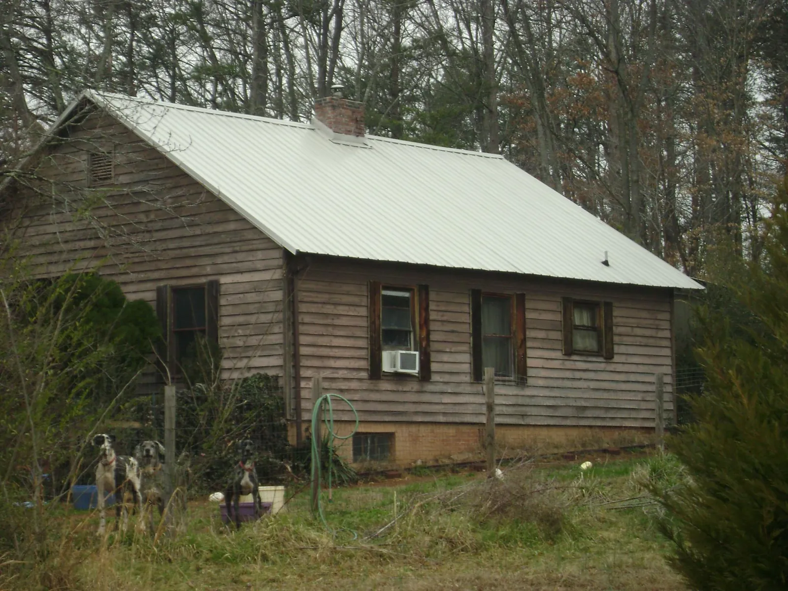 White metal roof on an old wood sided farmhouse, from a Metal Roof Installation job in Okeechobee